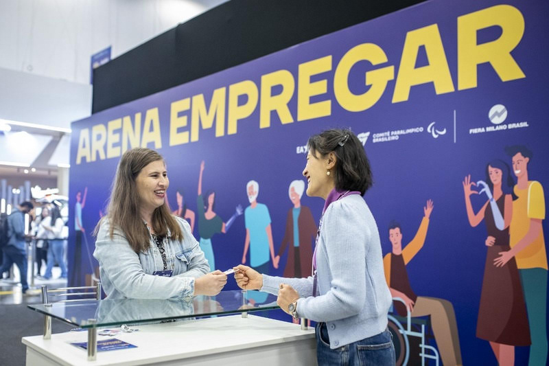 Pessoas interagindo no Arena Empregar da Reatech 2025, com destaque para inclusão e diversidade.