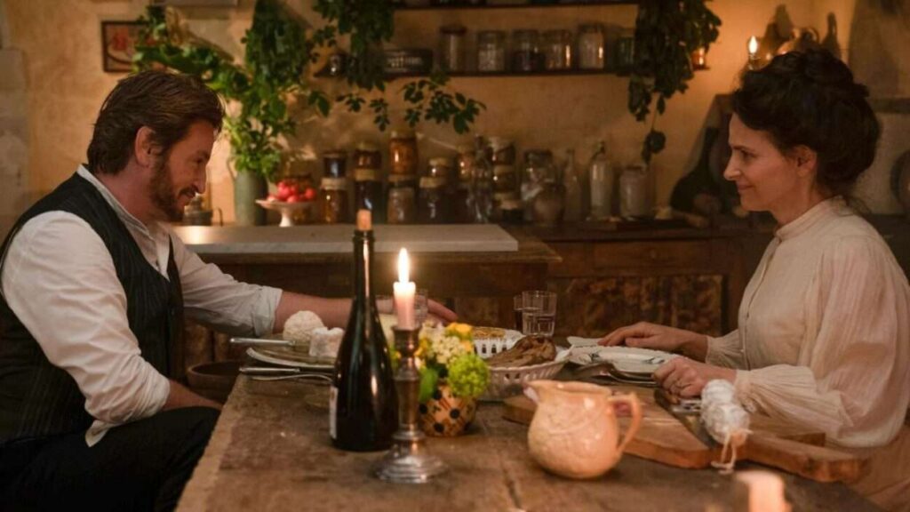 Cena do filme 'O Sabor da Vida' mostrando Eugénie e Dodin na cozinha, cercados por ingredientes frescos e coloridos que simbolizam amor e culinária.