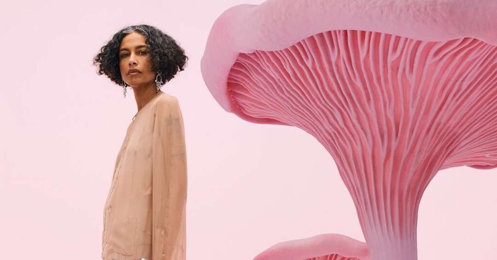 Mulher de 50 anos com cabelos grisalhos vestindo roupas de alta moda, representando a nova era de visibilidade na indústria da moda.